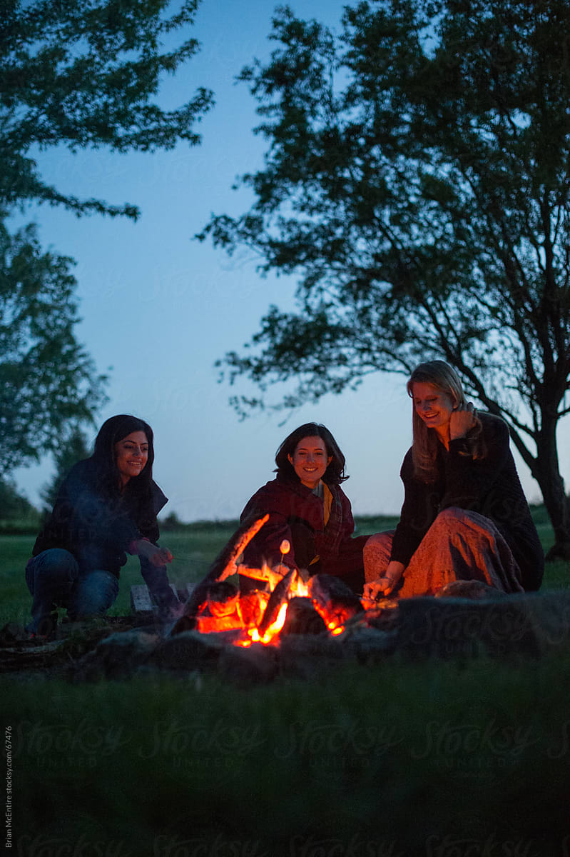 Camping Lifestyle: Women Roast Marshmallows Over Campfire