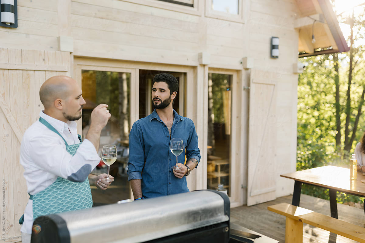 Two Men Preparing Barbecue Outdoors