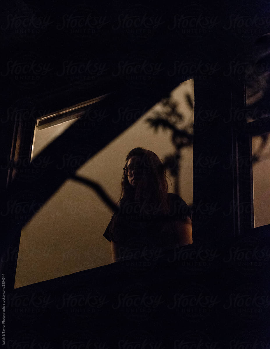 Person silhouette standing in a house window