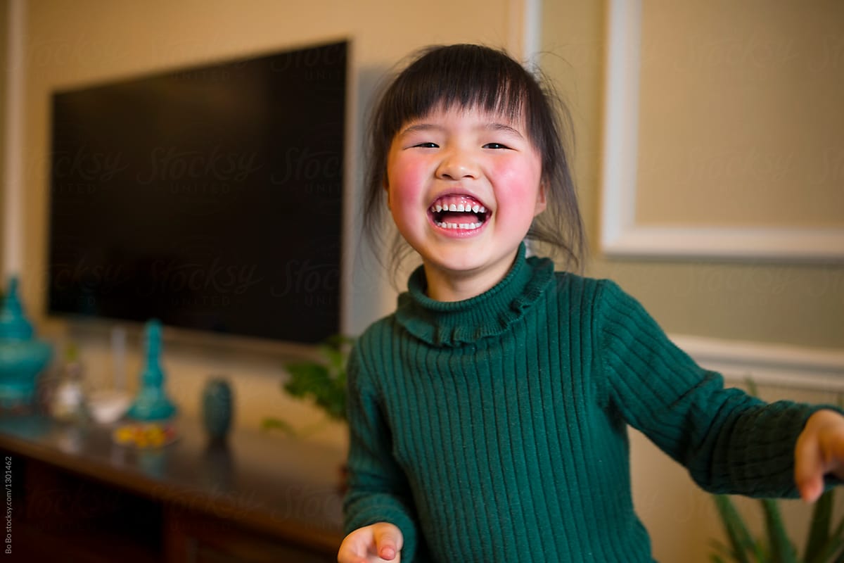 Little asian girl smile at camera in home
