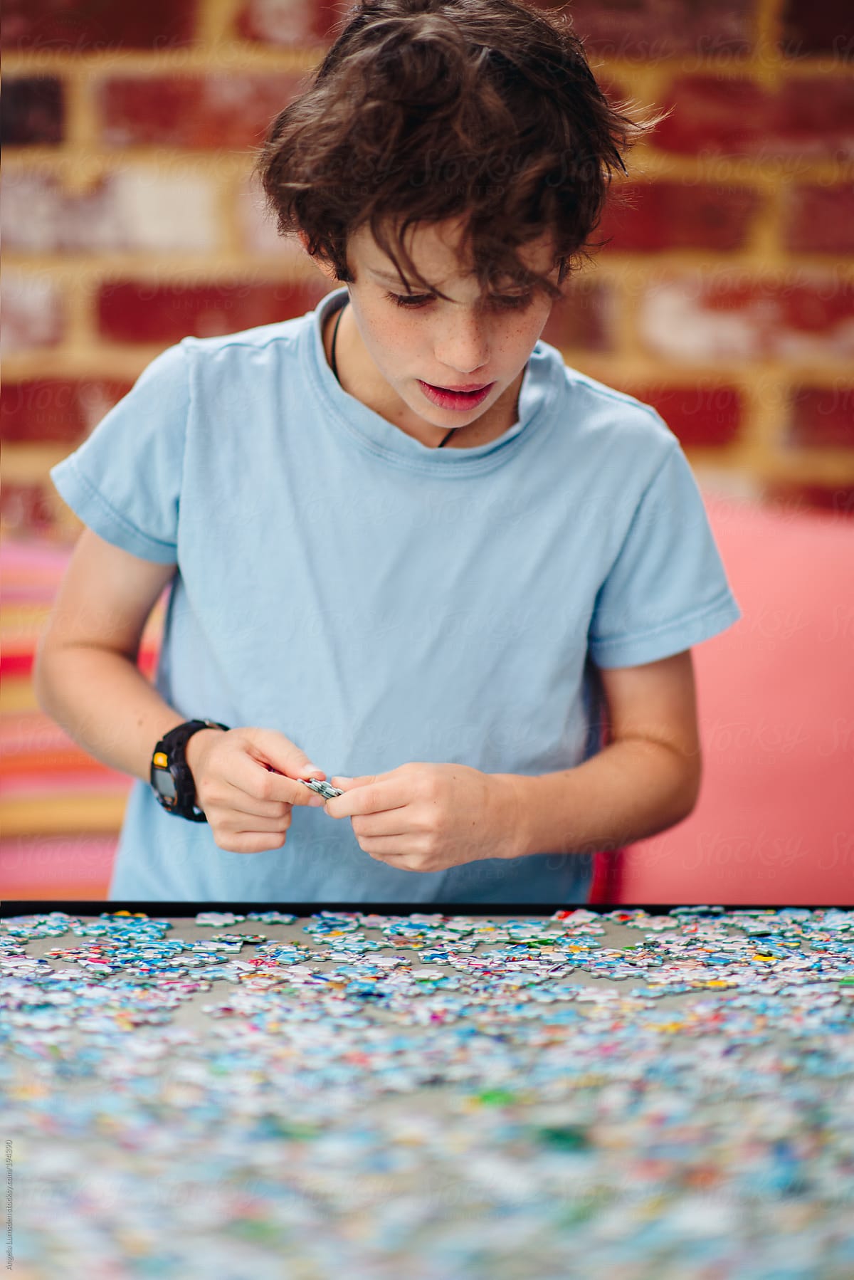 Boy working on a jigsaw puzzle outside