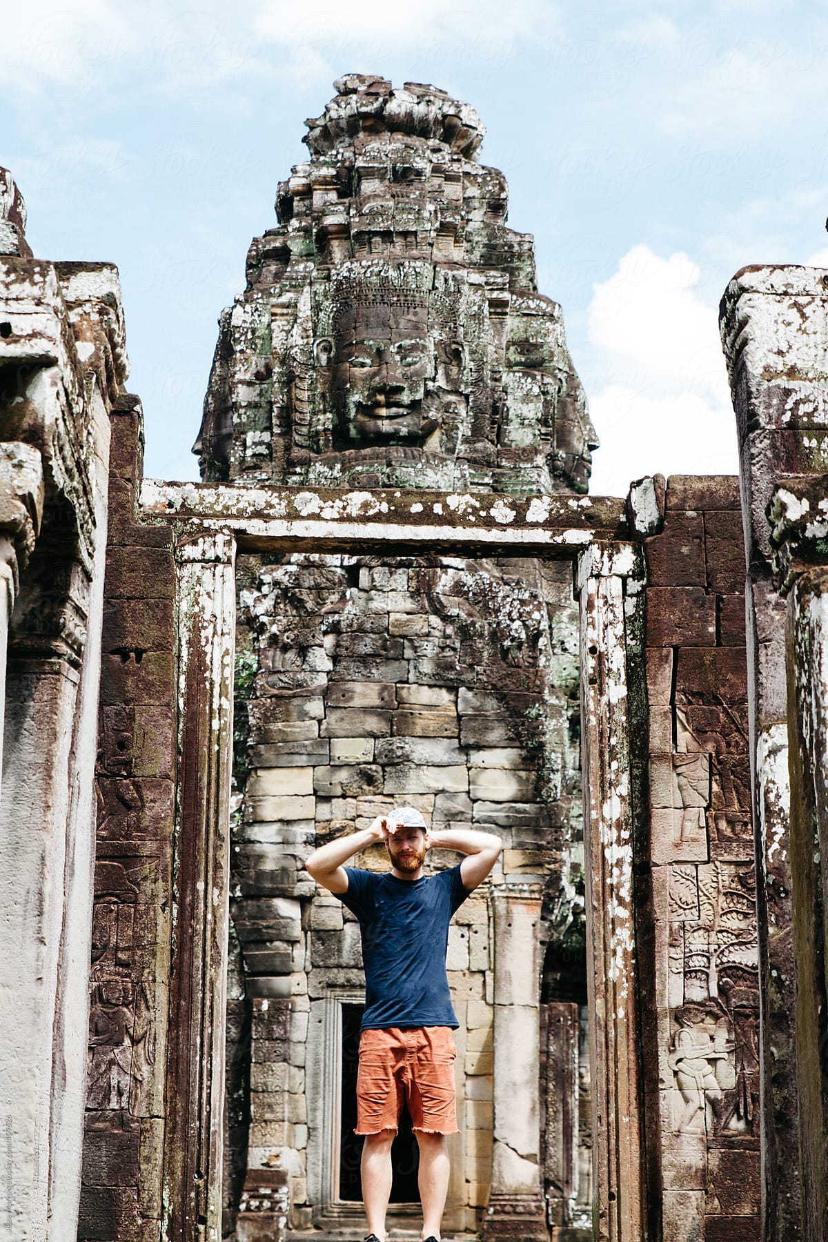 Young male stands in front of temple on adventure