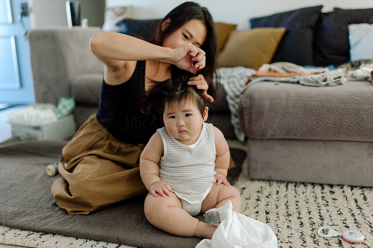 Mom is putting Asian baby\'s hair inept tail