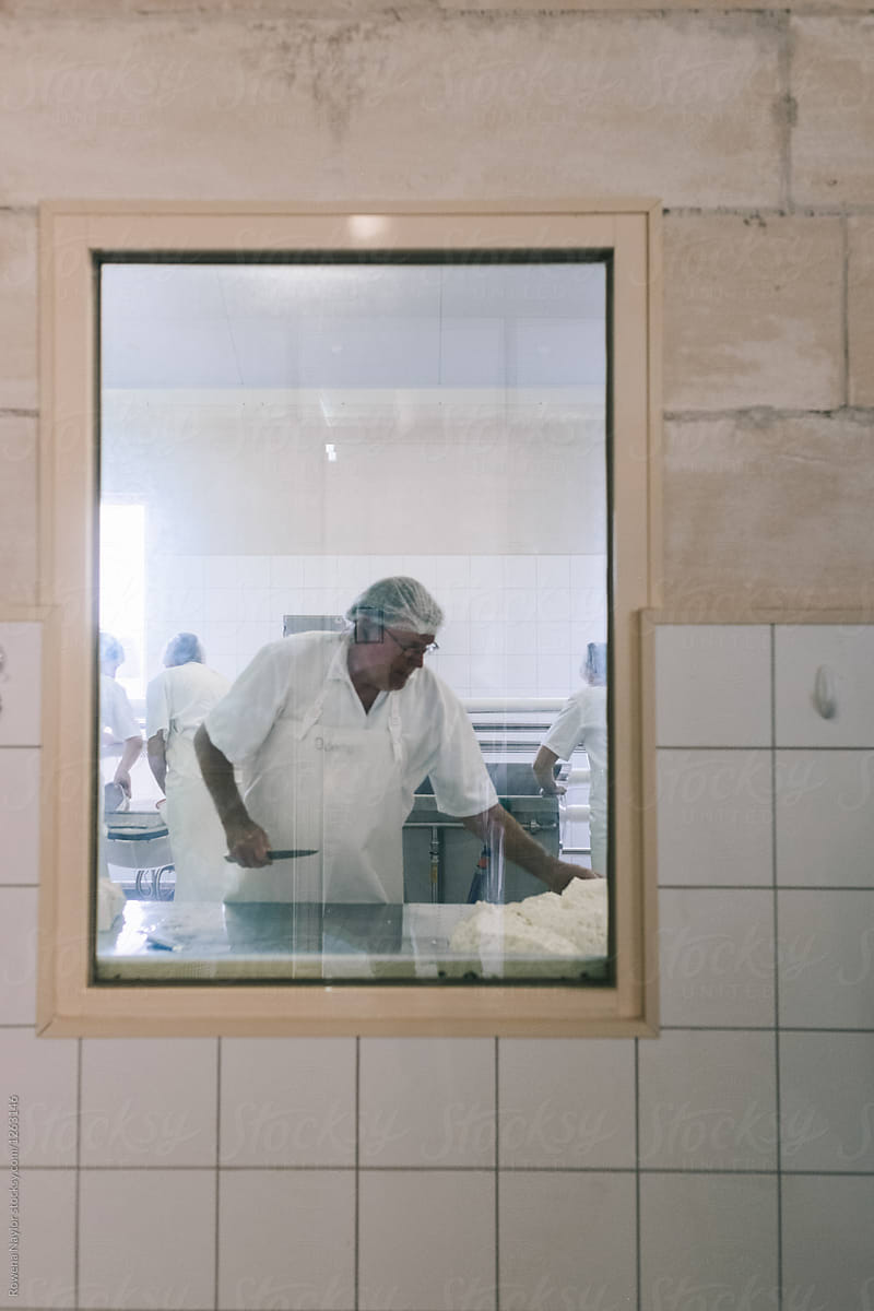 Cheese maker working in cheese factory