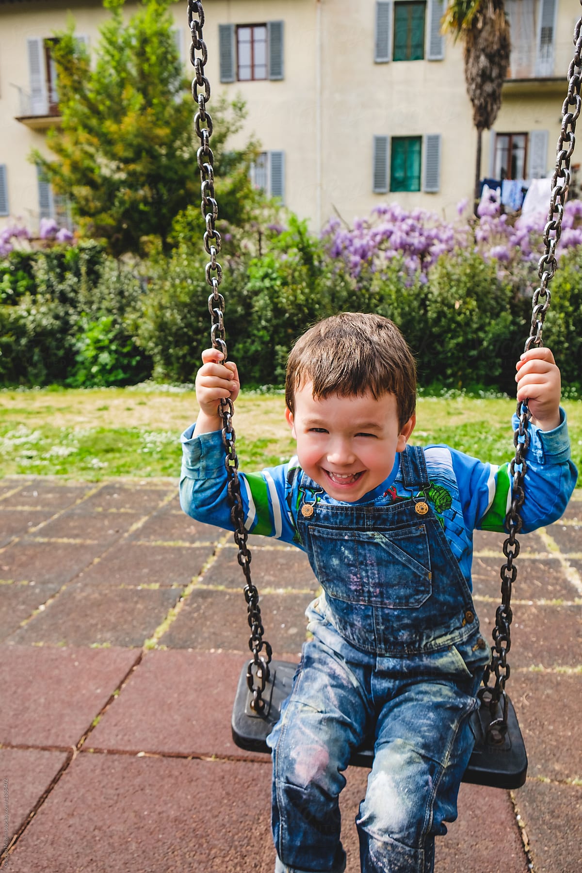 Preschooler Boy Having Fun on a Swing at the Playground