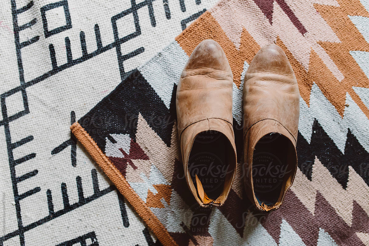 Worn leather booties on patterned rugs