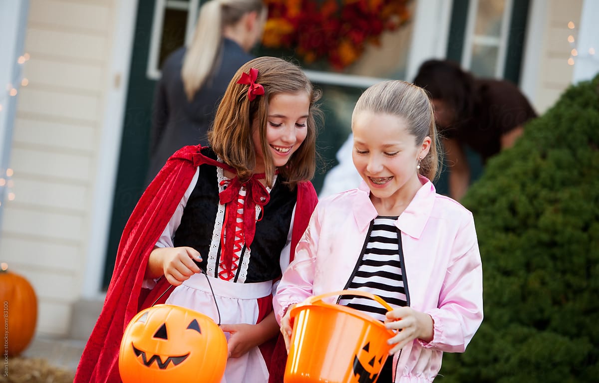 Halloween: Friends Look At Trick-Or-Treat Candy In Bucket