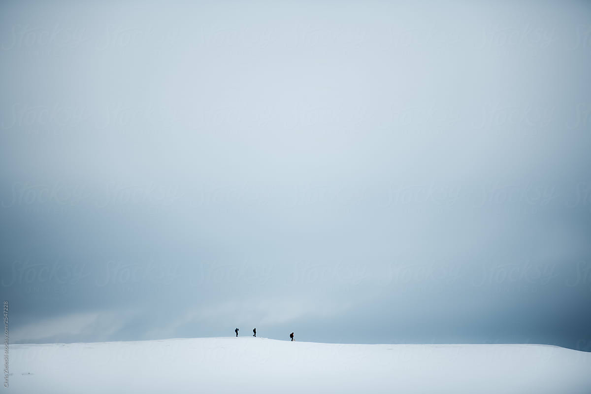 People hiking on snow covered glacier plateau