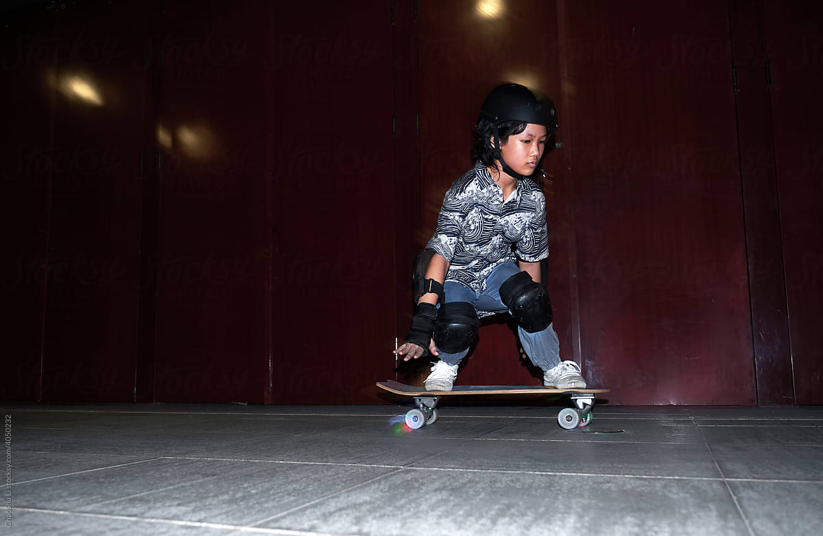 Asian girl playing land surf skateboard at night