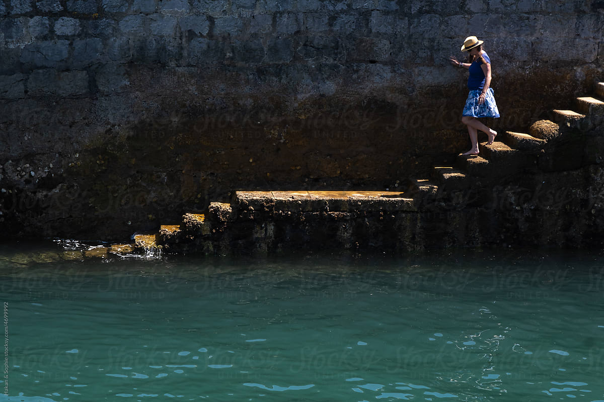 woman walking down the stairs that lead to the sea