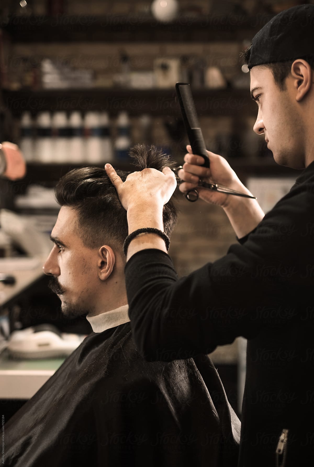 Young Barber Giving Client A Classic Haircut In Vintage