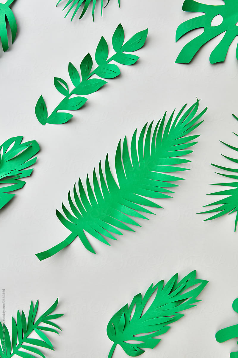 Green paper tropical leaves handmade pattern on a pastel backgro
