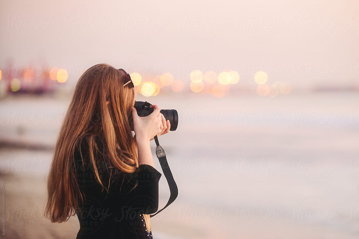 Teenage girl taking photos at the beach