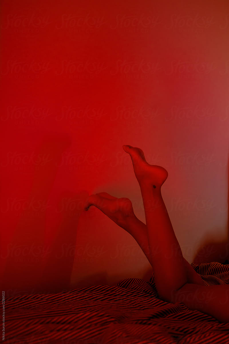 Elegant and feminine legs against the wall are posing. Red, bloody, frightening and sexy