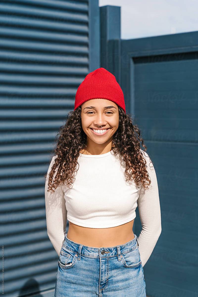 Smiling female in red hat on street