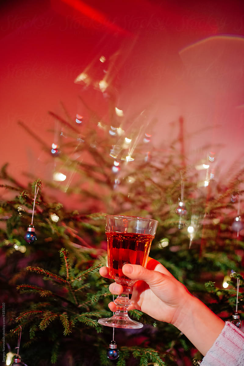 Female with glass of champagne against Christmas tree