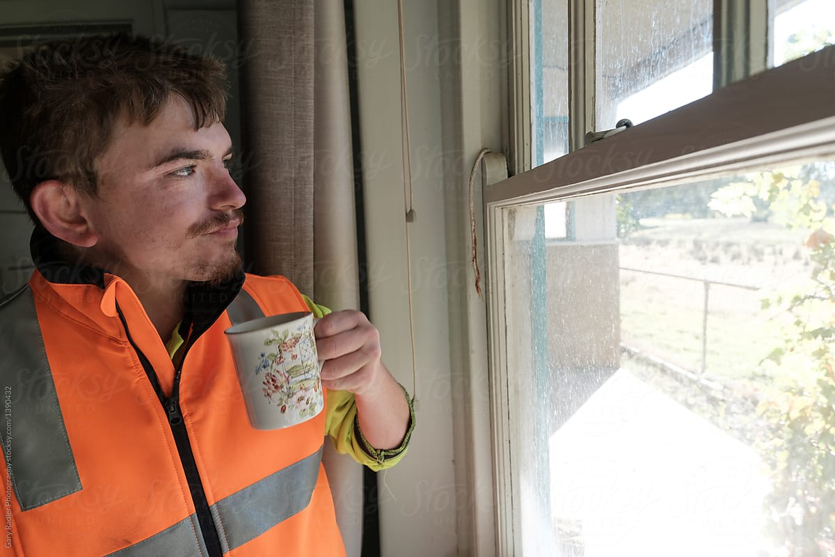 Man with Hi-Vis Top at Window with Cup of Tea