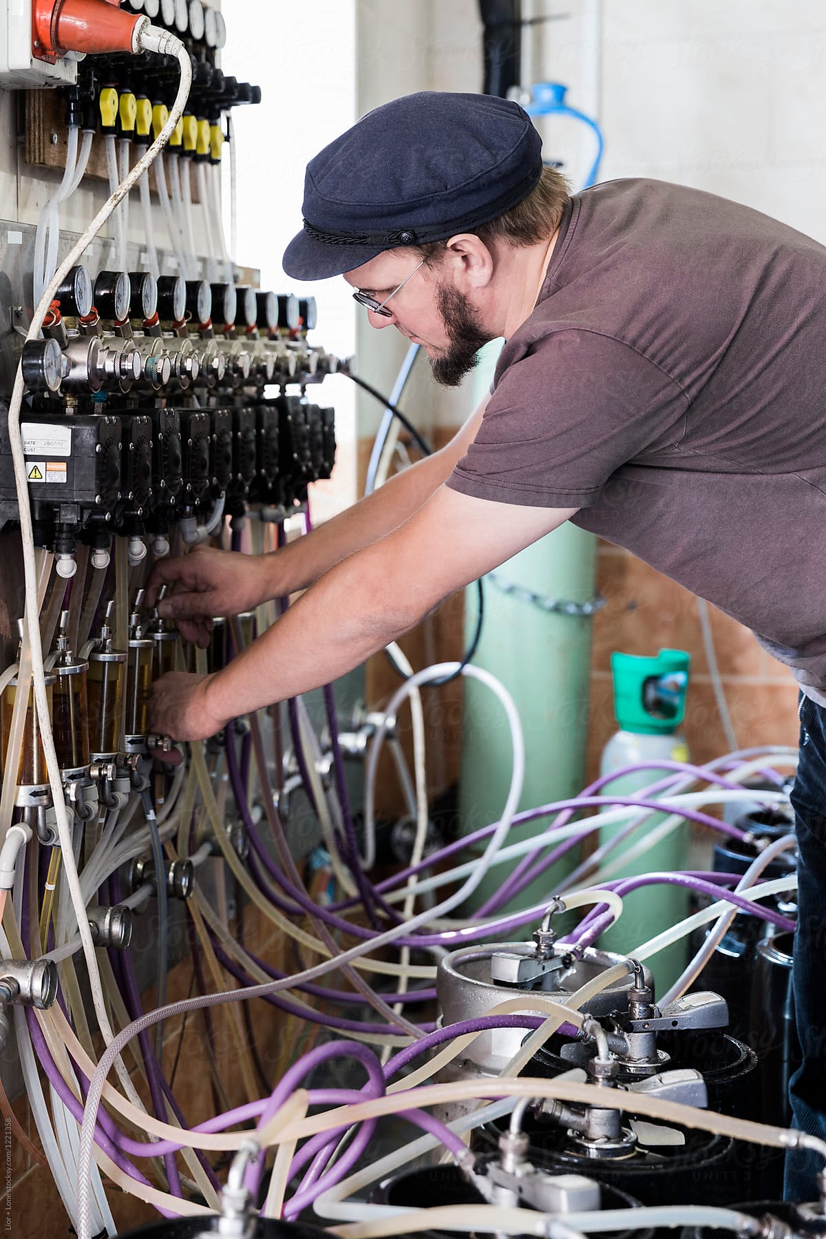 Brewmaster adjusting pressure gauge on beer kegs