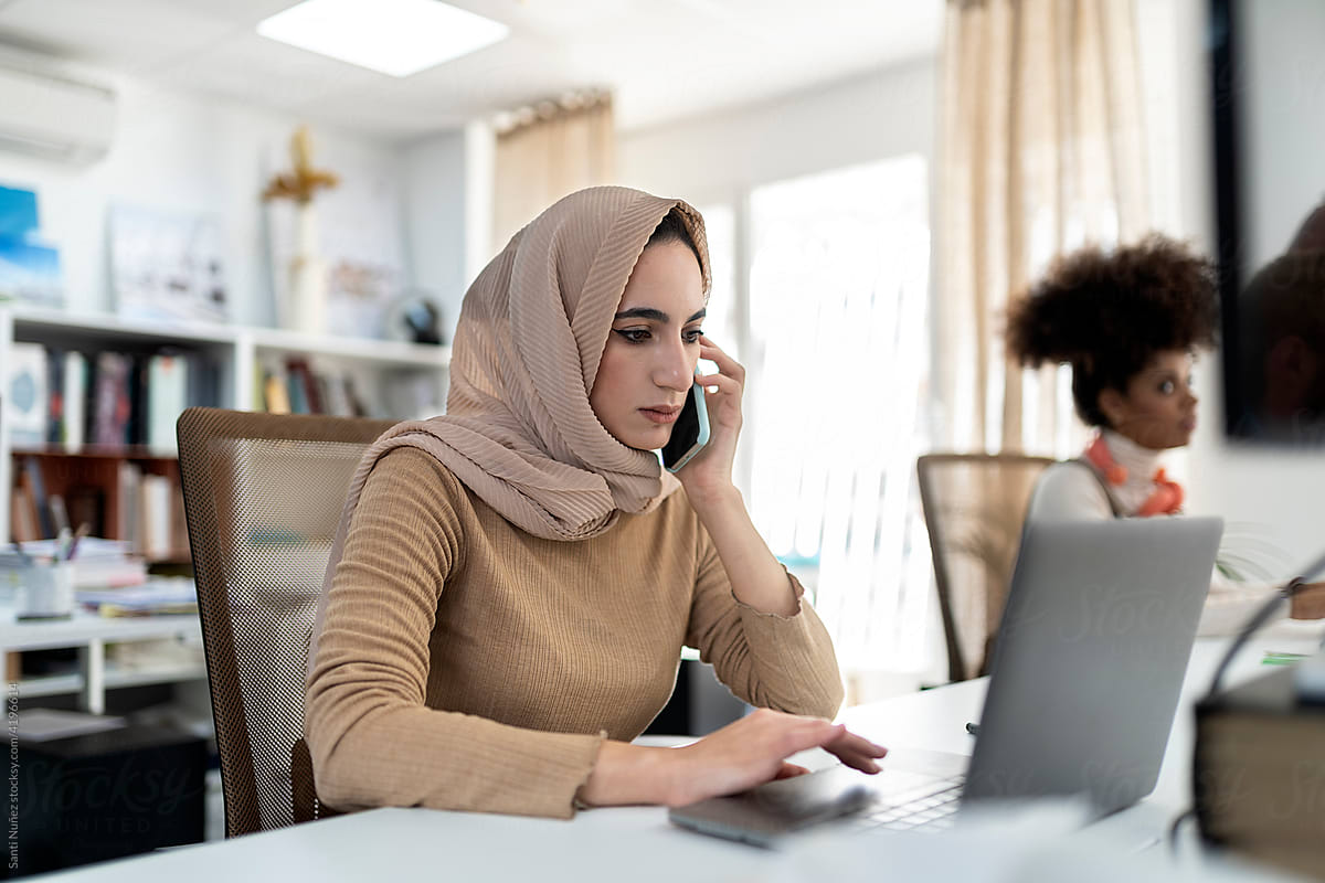 Muslim woman working in the office and talking on the smartphone