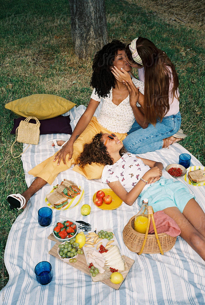 Multiethnic Lesbian Couple With Their Daughter Enjoying Picnic/ pic