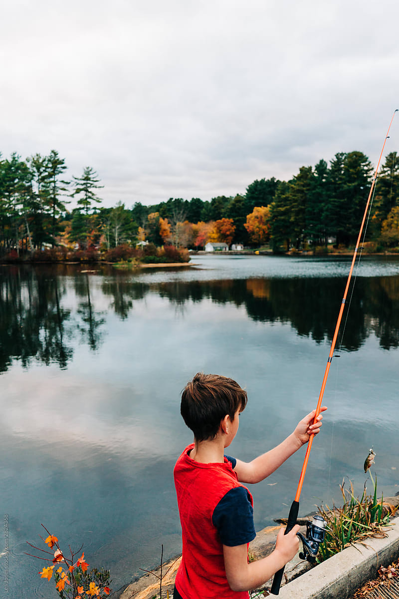 boy fishing in lake in the fall