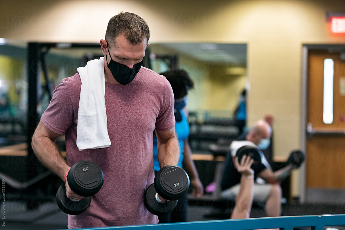 Gym: Man Picks Up Dumbbells To Work Out