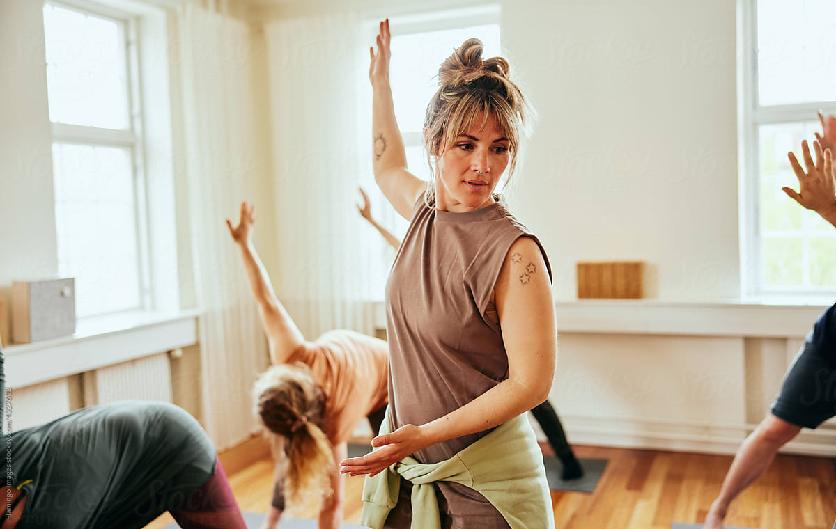 Fitness Woman Yoga teacher doing a class with students