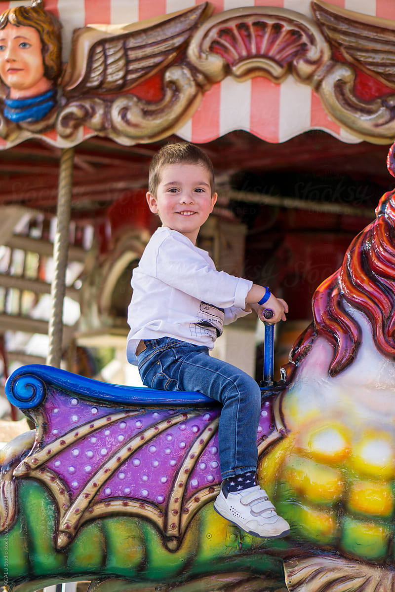 Boy riding on a carousel horse at the fair