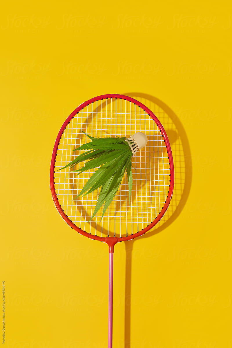 Green cannabis shuttlecock and badminton racket.
