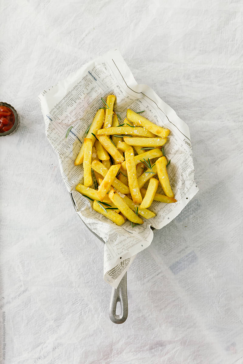 Skillet with newspaper wrapped chips/fries seasoned with sea salt and rosemary