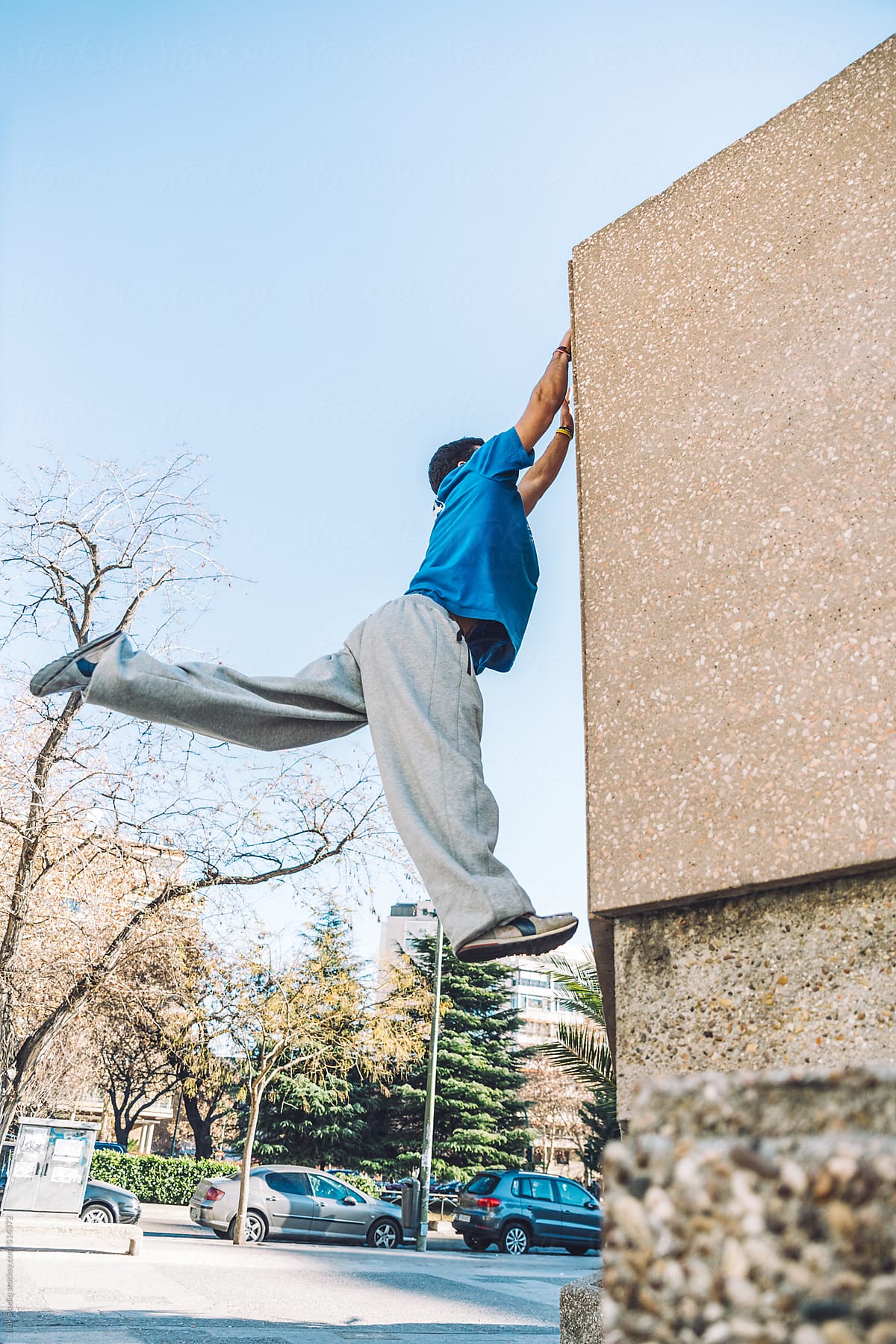 Man jumping and clutching during a parkour training in a city