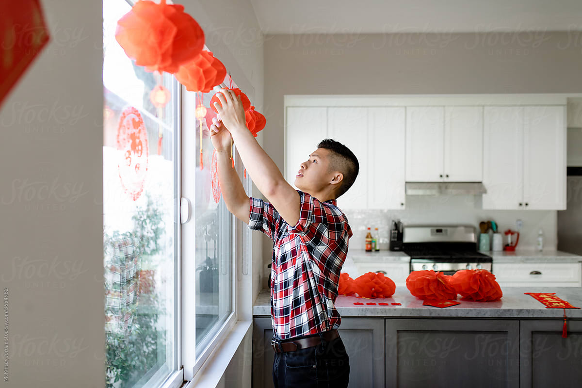 Young Man Hangs Red Lanterns for Chinese New Year