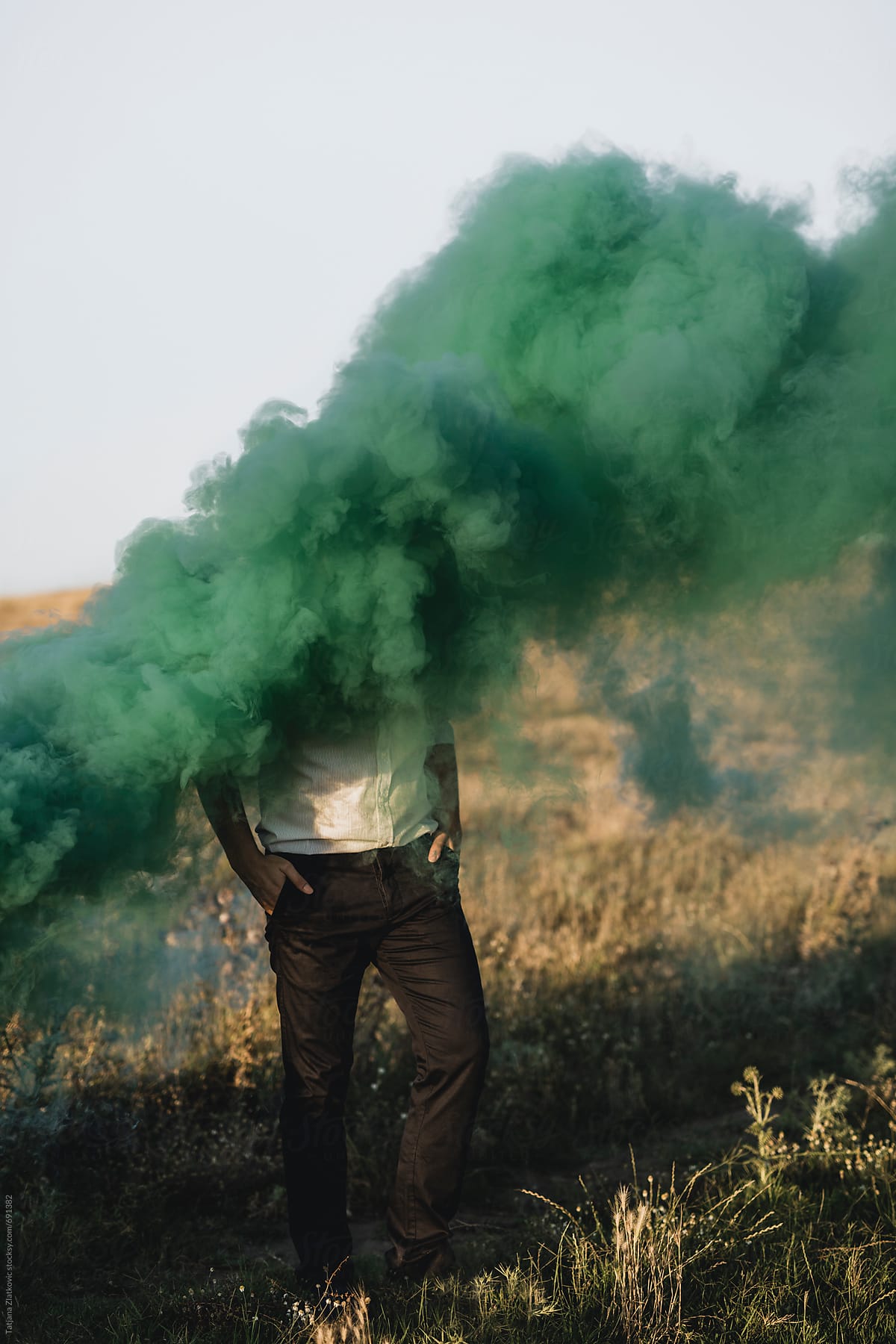 Young man in a green smoke cloud
