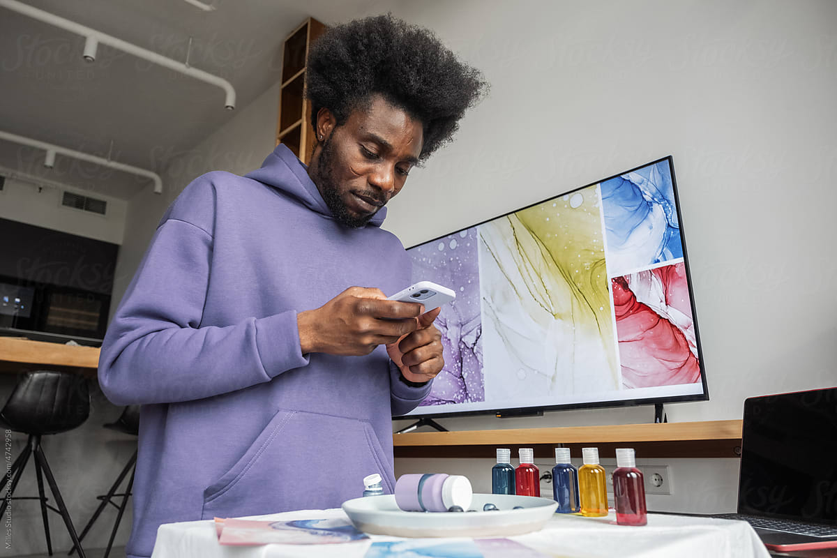 Black male artist taking photo for portfolio at home