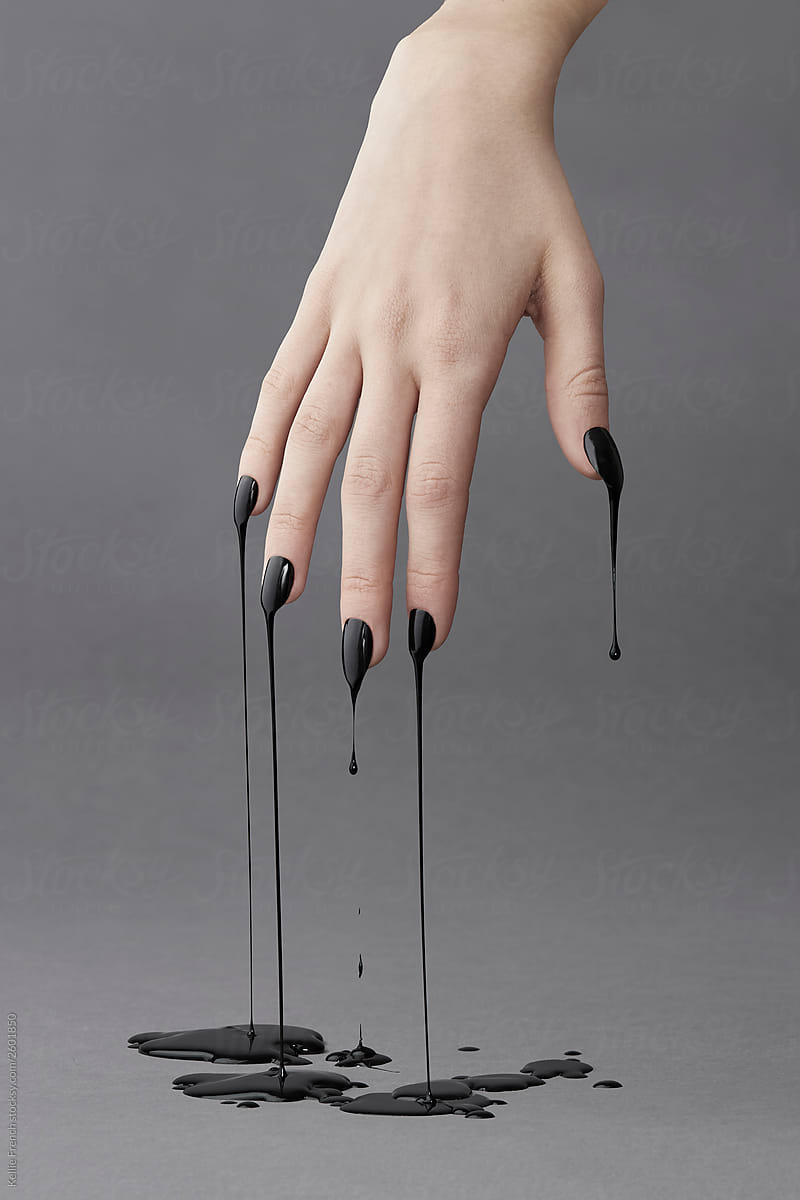 Hand dripping with black paint