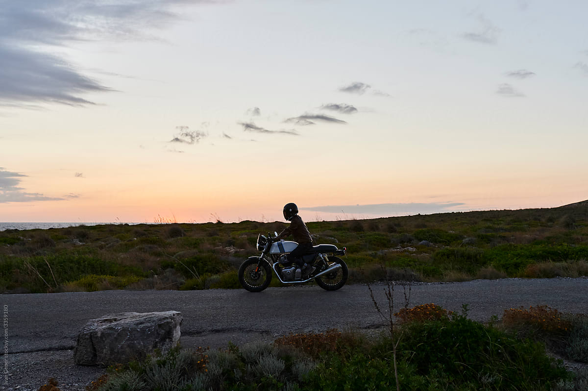 Biker riding along the coast at dusk