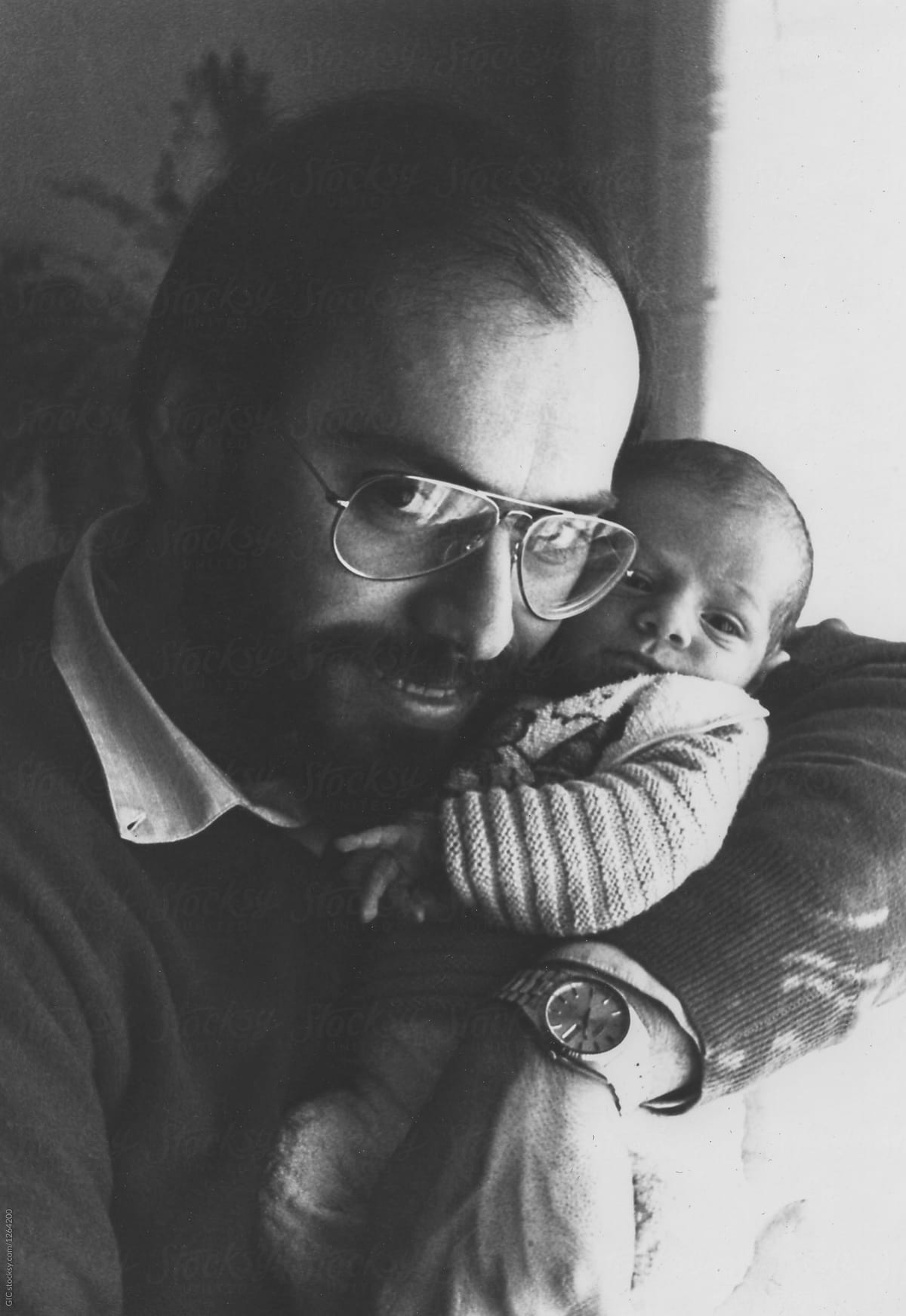 Man with his newborn son looking at camera