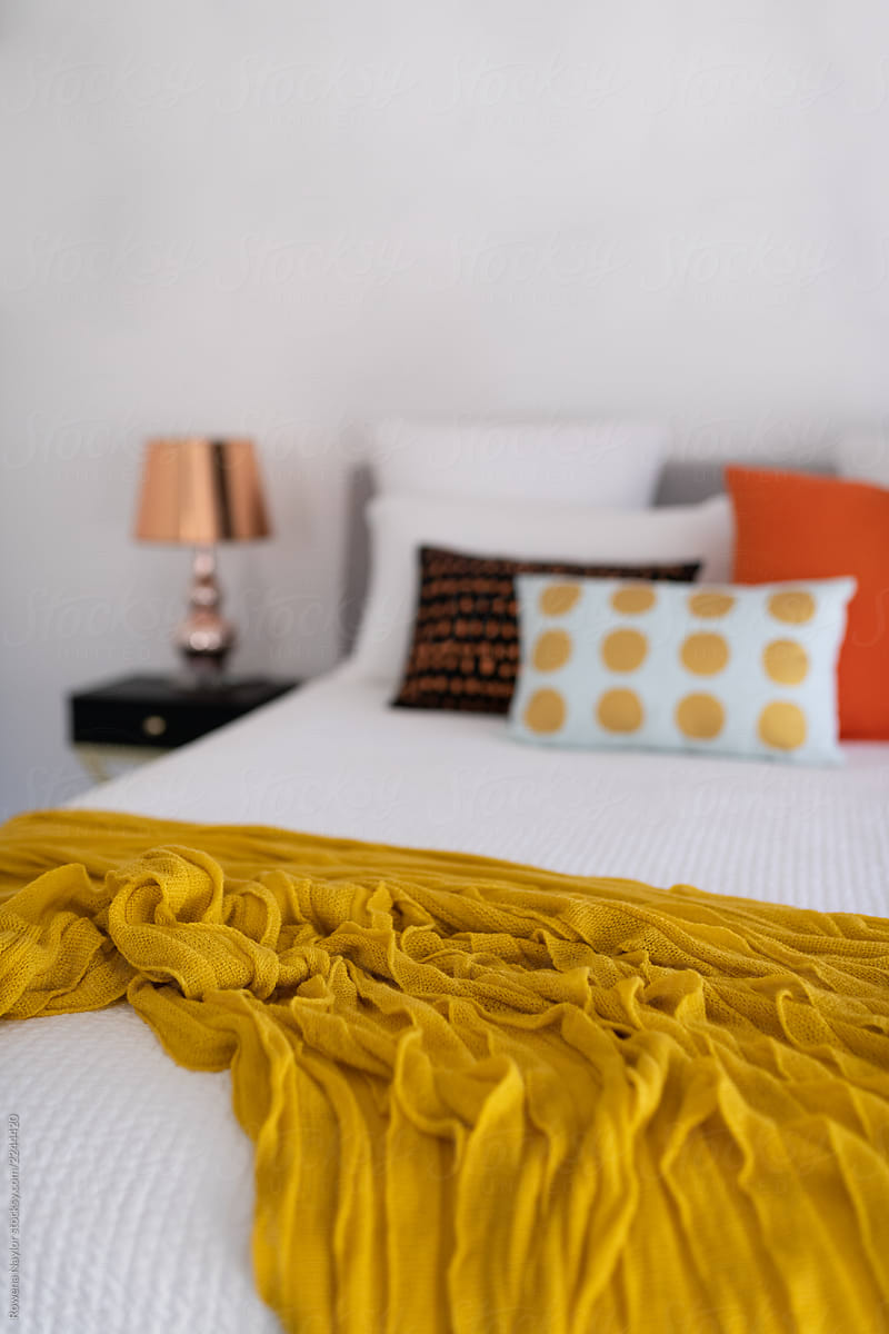 Styled bedroom with mustard and orange accent colors