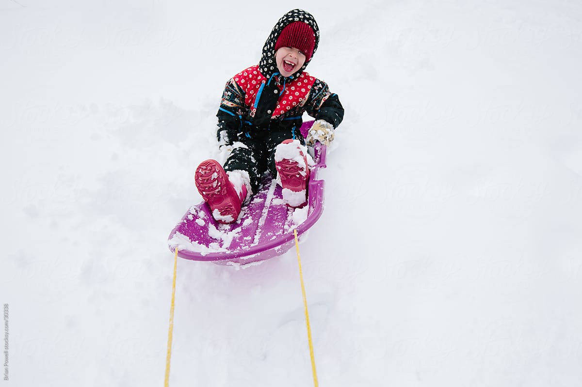 little girl being pulled on a sled