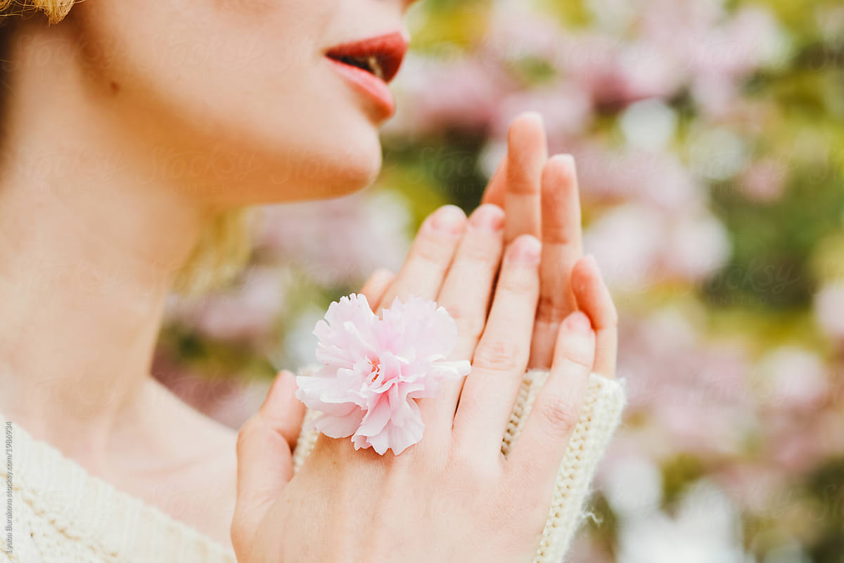 Crop portrait of a woman with sakura flower as a ring