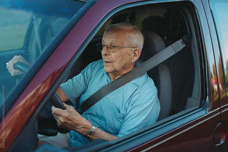 Concentrating senior man driving minivan