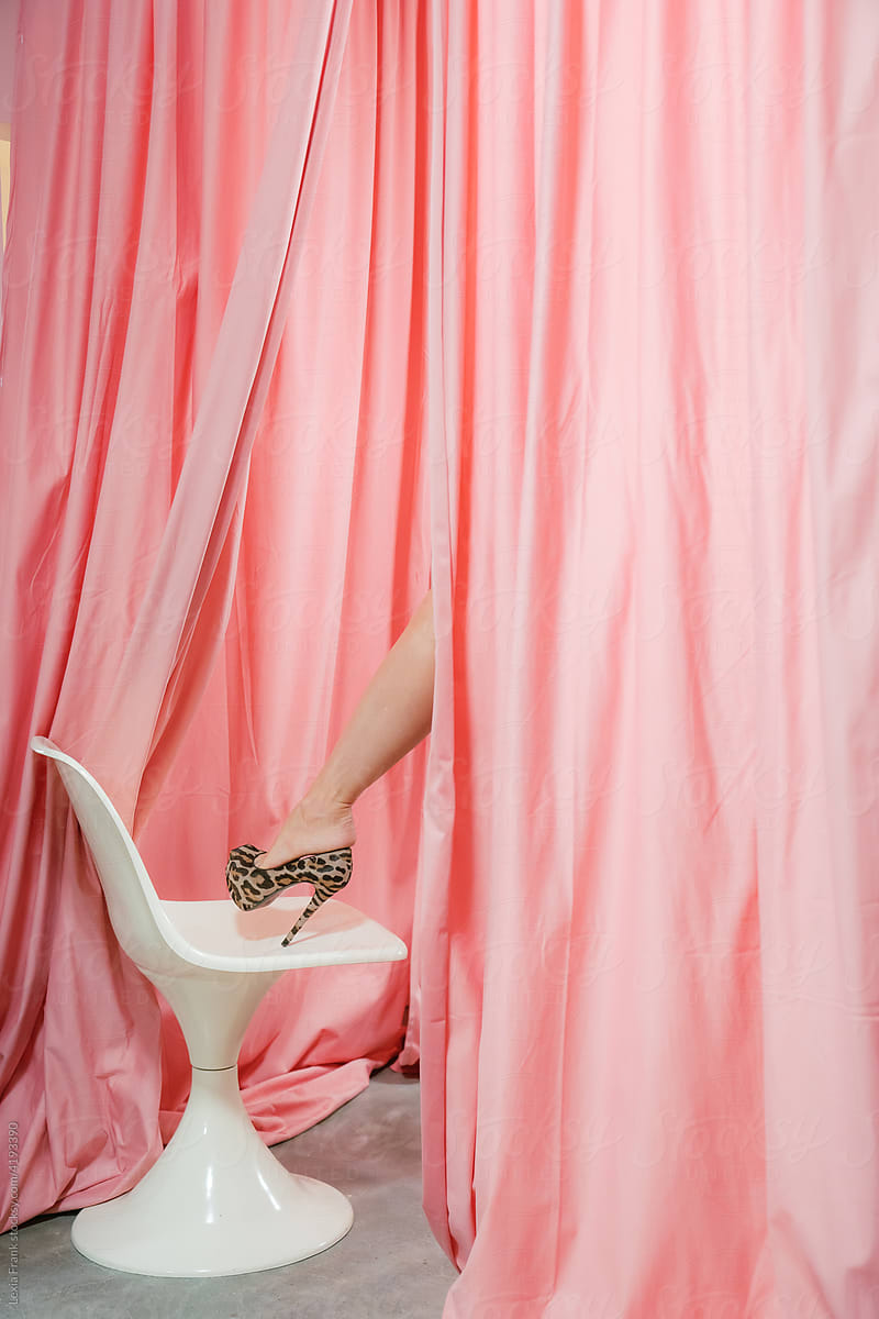 high heels leg on modern chair with pink curtain