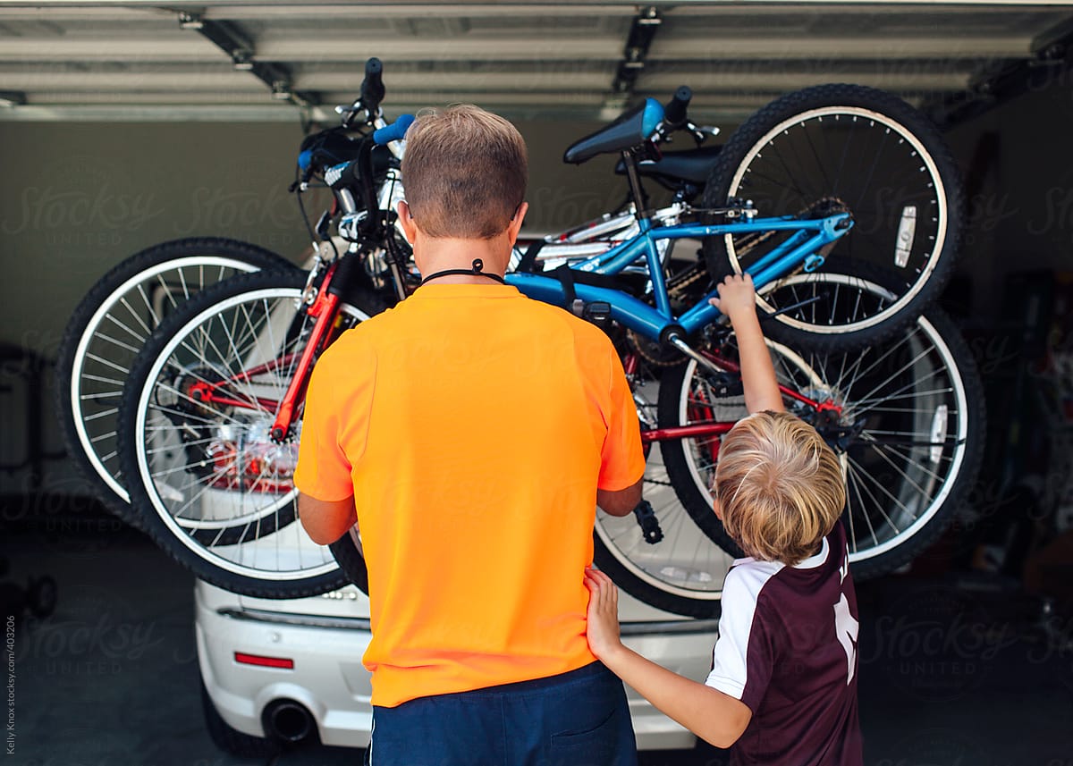 father and son loading bikes on the back of a vehicle