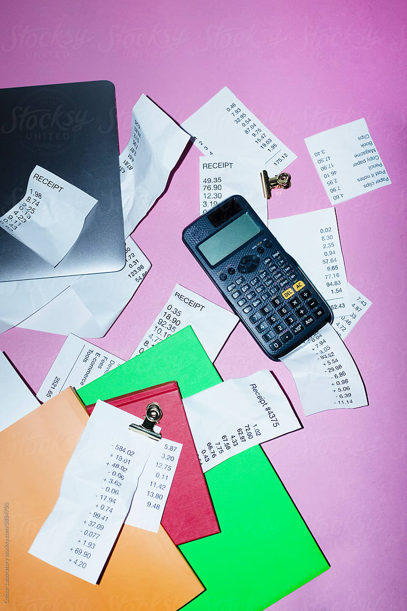 Accounting in office: receipts inside of books, laptop and calculator