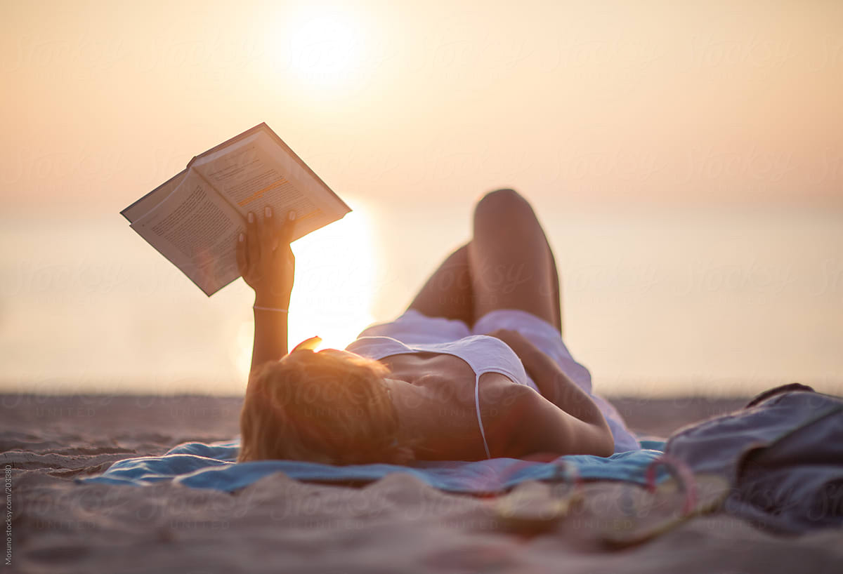 Young Woman Reading a Book at Sunset
