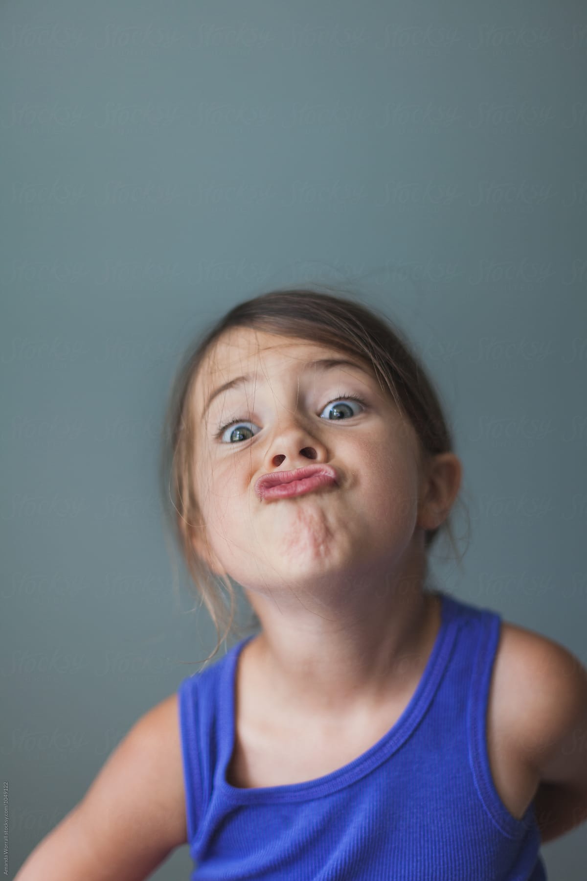 Simple indoor portrait of young girl making a silly face
