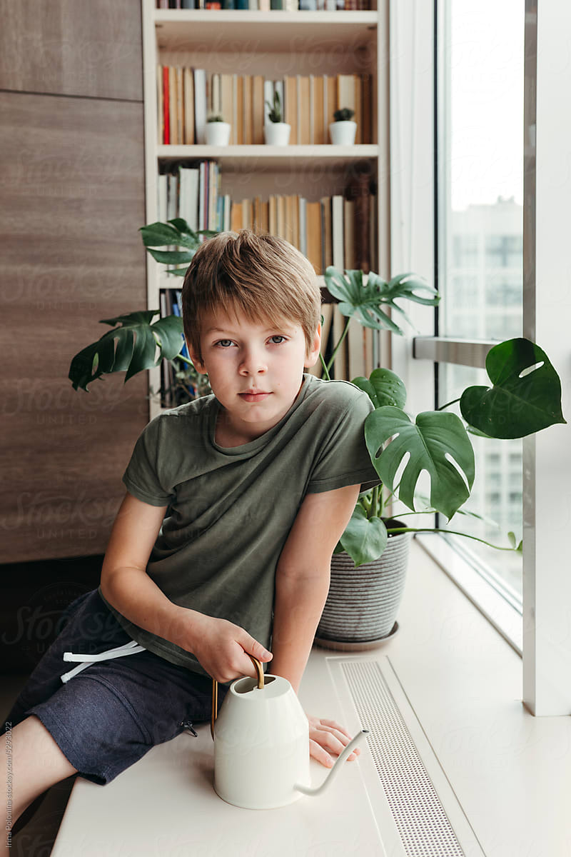 Portrait of kid takes care of houseplants.