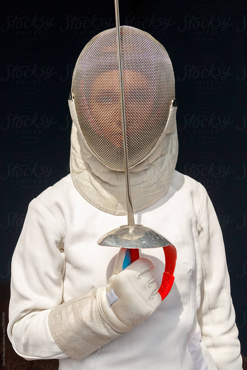 Female fencer touching helmet with foil