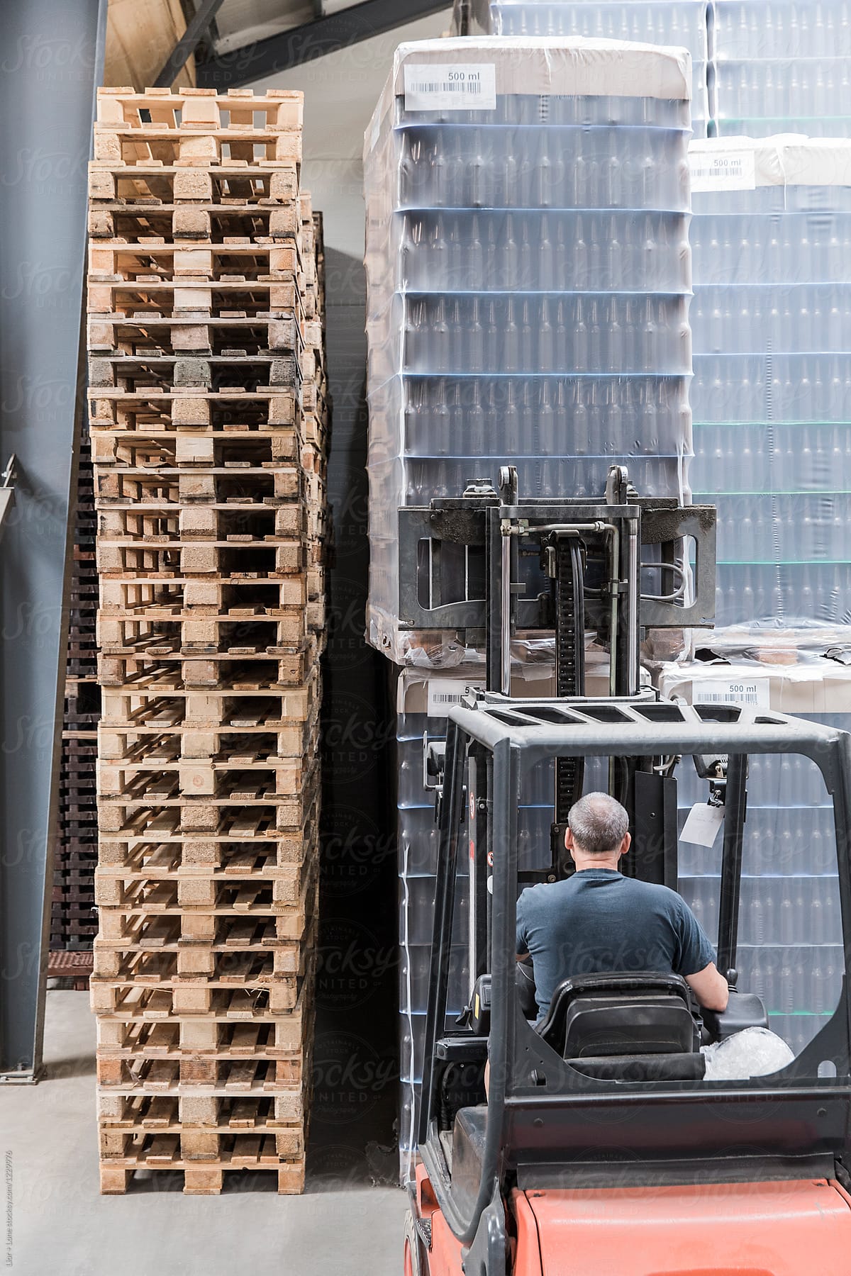 Man on a forklift moving crates of empty bottles