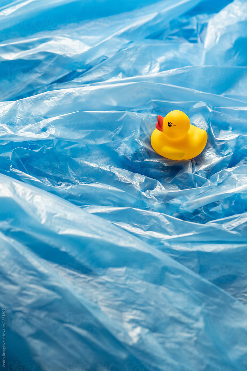 Rubber duck swim through the ocean from plastic bags
